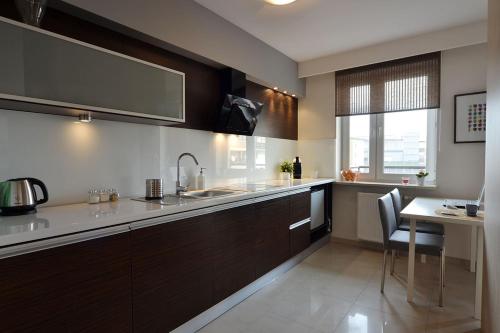 uma cozinha com um lavatório e um balcão com uma mesa em Apartament Classic em Kielce