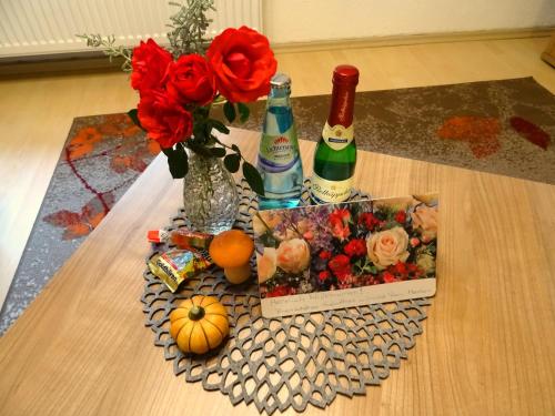 a table with a vase of flowers and wine bottles at Ferienwohnung Sobrigau in Sobrigau