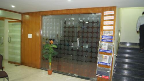 a glass door with a plant in front of it at Hotel MGM Grand in Srikalahasti