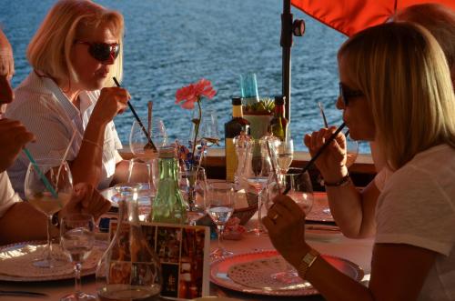 a group of people sitting at a table with wine glasses at Der Ronacherfels in Weissensee