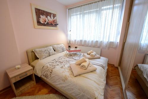 a small bedroom with a bed with towels on it at Apartman Centar Lux Valjevo in Valjevo
