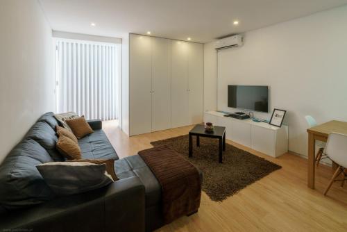 a living room with a couch and a television at I Love Vila do Conde in Vila do Conde