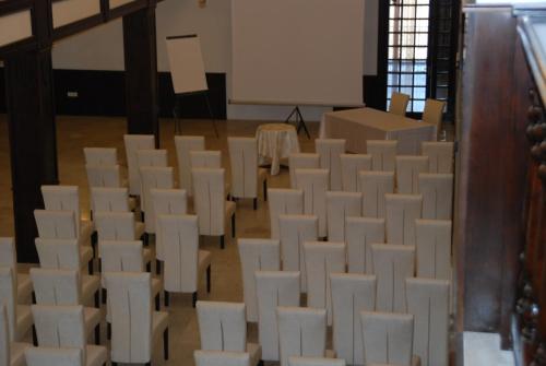 an empty room with white chairs and a whiteboard at Hanul Domnesc in Braşov