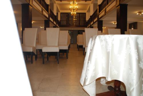 a dining room with white chairs and a table at Hanul Domnesc in Braşov
