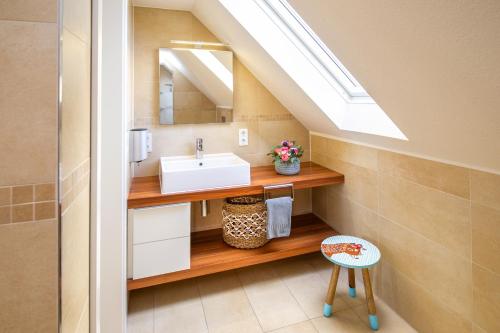 ein Badezimmer mit einem Waschbecken und einem Dachfenster in der Unterkunft Familienhaus Feuerstein in Wangerooge