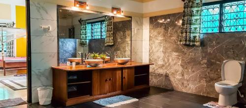 a bathroom with a sink and a toilet at Jamboland-Diani in Diani Beach