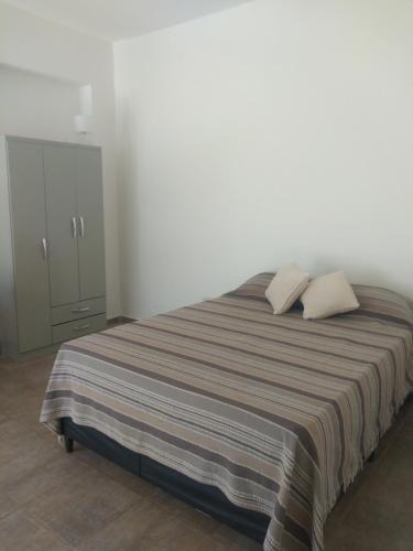 1 dormitorio con 1 cama grande y 2 almohadas en Departamento Amoblado en Villa María