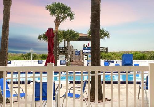 a view of a pool with chairs and palm trees at Guy Harvey Resort on Saint Augustine Beach in Saint Augustine Beach
