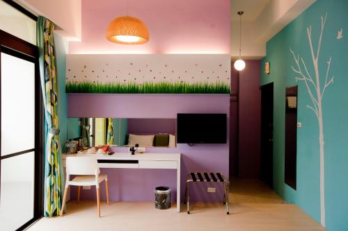 a room with a desk and a wall with grass on it at Hualien KeyInn Space in Hualien City