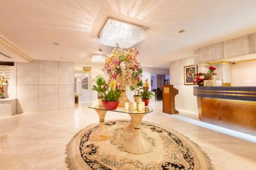a lobby with a table with flowers on it at Amman International Hotel in Amman