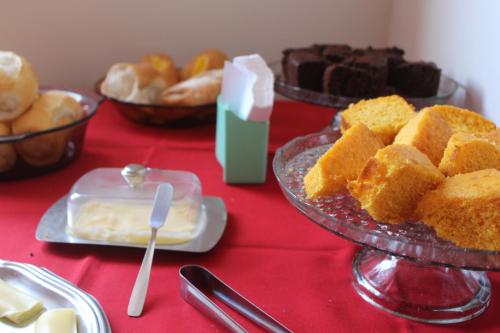 Una mesa cubierta con platos de pasteles y otros postres. en Hotel Nossa Senhora Aparecida, en Ouro Preto