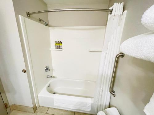 uma casa de banho branca com uma banheira e um chuveiro em Holiday Inn Express & Suites Shelbyville, an IHG Hotel em Shelbyville