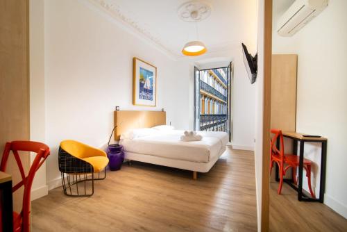 ein Hotelzimmer mit einem Bett, einem Tisch und Stühlen in der Unterkunft Central Roomss in San Sebastián