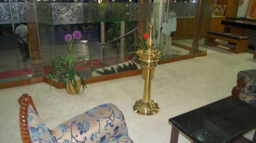 a living room with a vase and a gold pole at Hotel MGM Grand in Srikalahasti
