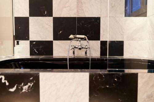 a bathroom with a bath tub with a faucet at Hôtel du Sentier in Paris