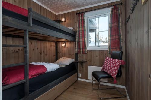 a bedroom with two bunk beds and a chair at Mountain Lodge, ToppTrysil 6+1 guest -Skihytta in Trysil