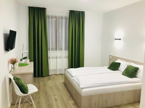 1 dormitorio con 1 cama y cortina verde en Vila Nona Apartment en Sibiu