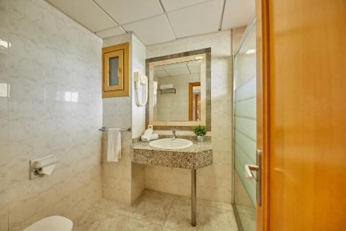 y baño con lavabo y espejo. en Apartamentos Ben-Hur, en Playa de Palma