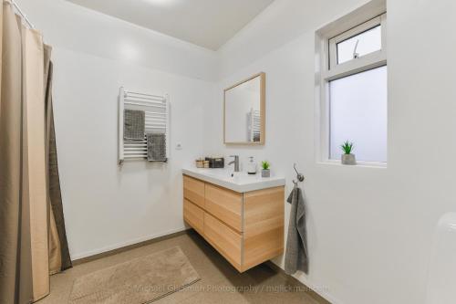 a white bathroom with a sink and a window at Syðra-Skörðugil Guesthouse in Varmahlid