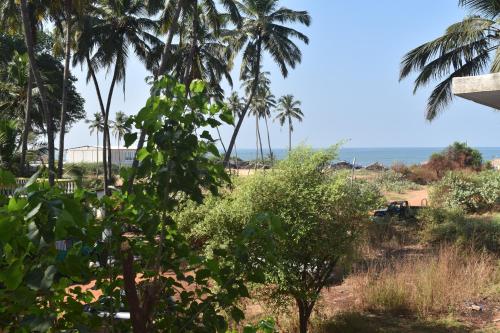 a view of palm trees and the ocean at Spectrum Hub beach side Studio Apartment - Candolim - Goa in Candolim