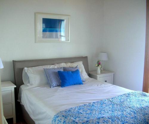 a bed with two blue pillows on top of it at Kefalas nr Almyrida sea view cottage in Chania Town