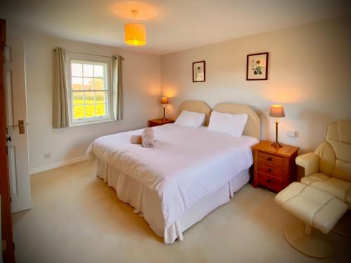 a bedroom with a large white bed and a window at Peaceful 2 bedroom granite country dower house in La Villaise