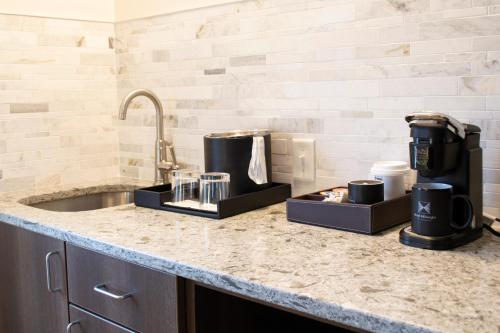 a kitchen counter with a sink with two containers on it at Hotel Millwright in Amana