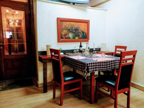 a dining room with a table with chairs and a painting at Urban Boutique Hotel in Pristina