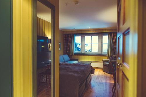a bedroom with a bed and a desk and a window at Gudbrandsgard Hotel in Kvitfjell