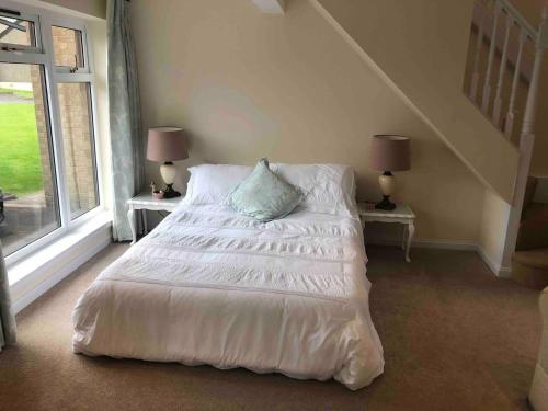 a bedroom with a white bed with two tables and two lamps at Lovely 1-Bed House in Stirling in Stirling