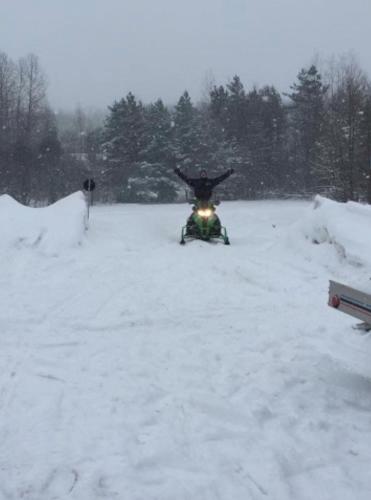 a person on a snowmobile in the snow at red maple inn and suites in Huntsville