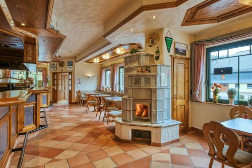 a restaurant with a fireplace in the middle of a room at Hotel Haus Tiefenbach in Bullange
