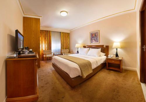 a hotel room with a bed and a television at Amman International Hotel in Amman