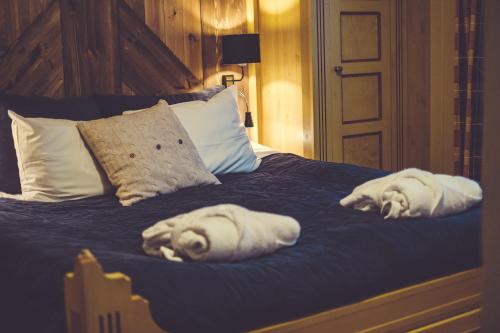 a bed with white towels laying on top of it at Gudbrandsgard Hotel in Kvitfjell