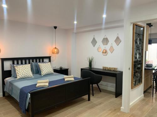 a bedroom with a bed and a table and a desk at UIM Mediterraneo Buenavista Wifi in Puerto de Sagunto