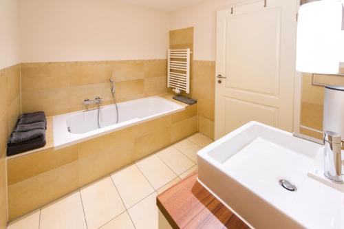 a bathroom with a tub and a sink at Schwedenhus in Wangerooge