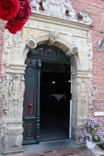 an entrance to a building with a green door and flowers at Gasthof Oldenwöhrden in Wöhrden