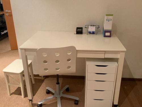 a white desk with a chair in an office at Charming 2-Bed Apartment in Arlesheim 15 min Basel in Arlesheim