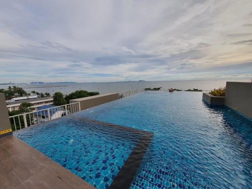 a large swimming pool with a view of the ocean at The Exclusive @WON Beach Suite & Toproof Pool in Ban Bang Saen (1)