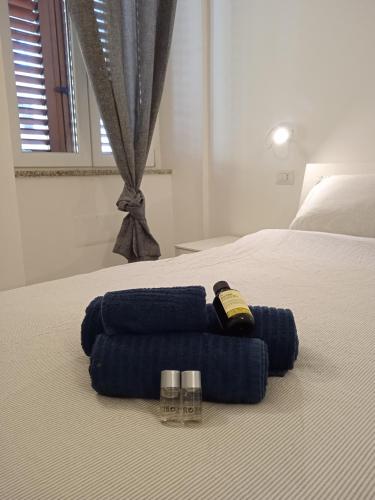 - un lit avec des serviettes bleues et 2 lunettes dans l'établissement Affittacamere dei Mercanti, à Sassari