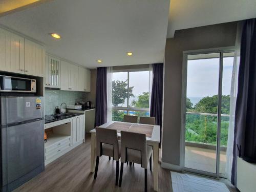 a kitchen with a table and chairs and a large window at The Exclusive @WON Beach Suite & Toproof Pool in Ban Bang Saen (1)