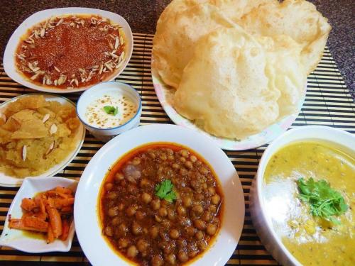 une table recouverte de assiettes de nourriture avec des haricots et du pain dans l'établissement Diamond Lodge, à Karachi
