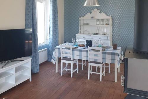 une cuisine avec une table et des chaises dans une pièce dans l'établissement maison 2 chambres spa Crozon proximité plages, à Telgruc-sur-Mer