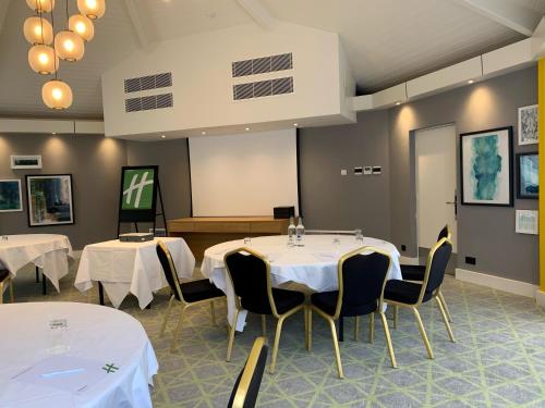 a room with two tables and chairs with white table cloth at Holiday Inn Dover by IHG in Dover
