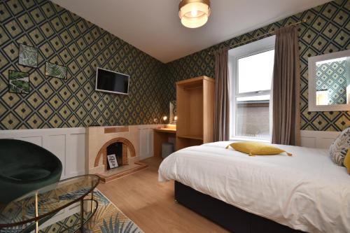 a bedroom with a bed and a fireplace at Signature Apartments in Fraserburgh