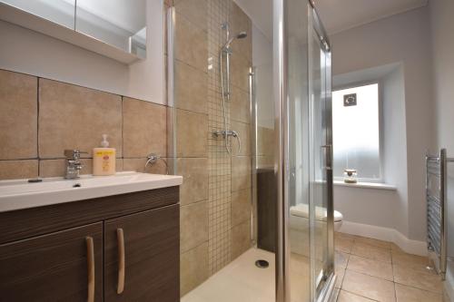 a bathroom with a shower and a sink and a toilet at Signature Apartments in Fraserburgh