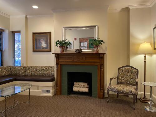 a living room with a fireplace and a chair at Oasis Guest House in Boston
