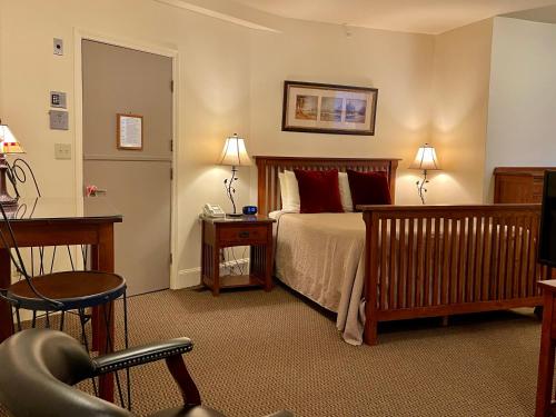 a bedroom with a bed and a desk and a chair at Oasis Guest House in Boston