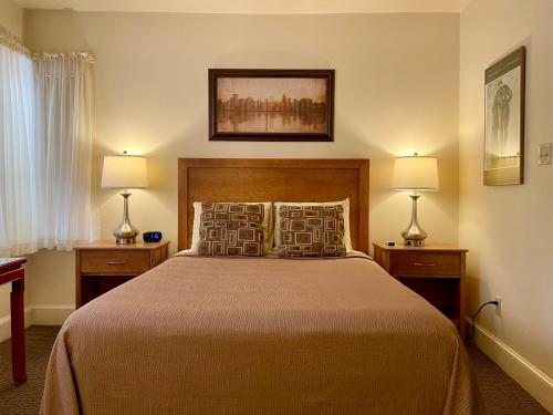 a bedroom with a large bed with two lamps at Oasis Guest House in Boston