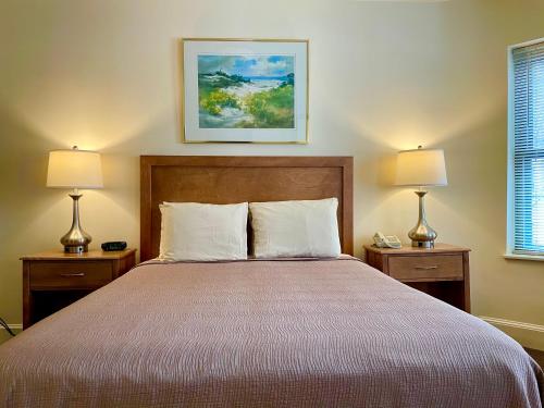 a bedroom with a large bed with two lamps at Oasis Guest House in Boston